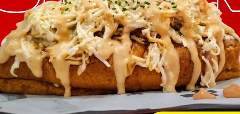 Hot Dog Urban coronado con queso rallado y salsas de la casa